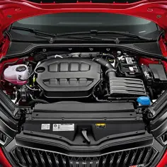 Czerwony samochód Skoda z otwartą maską, widoczny silnik i elementy komory silnika.